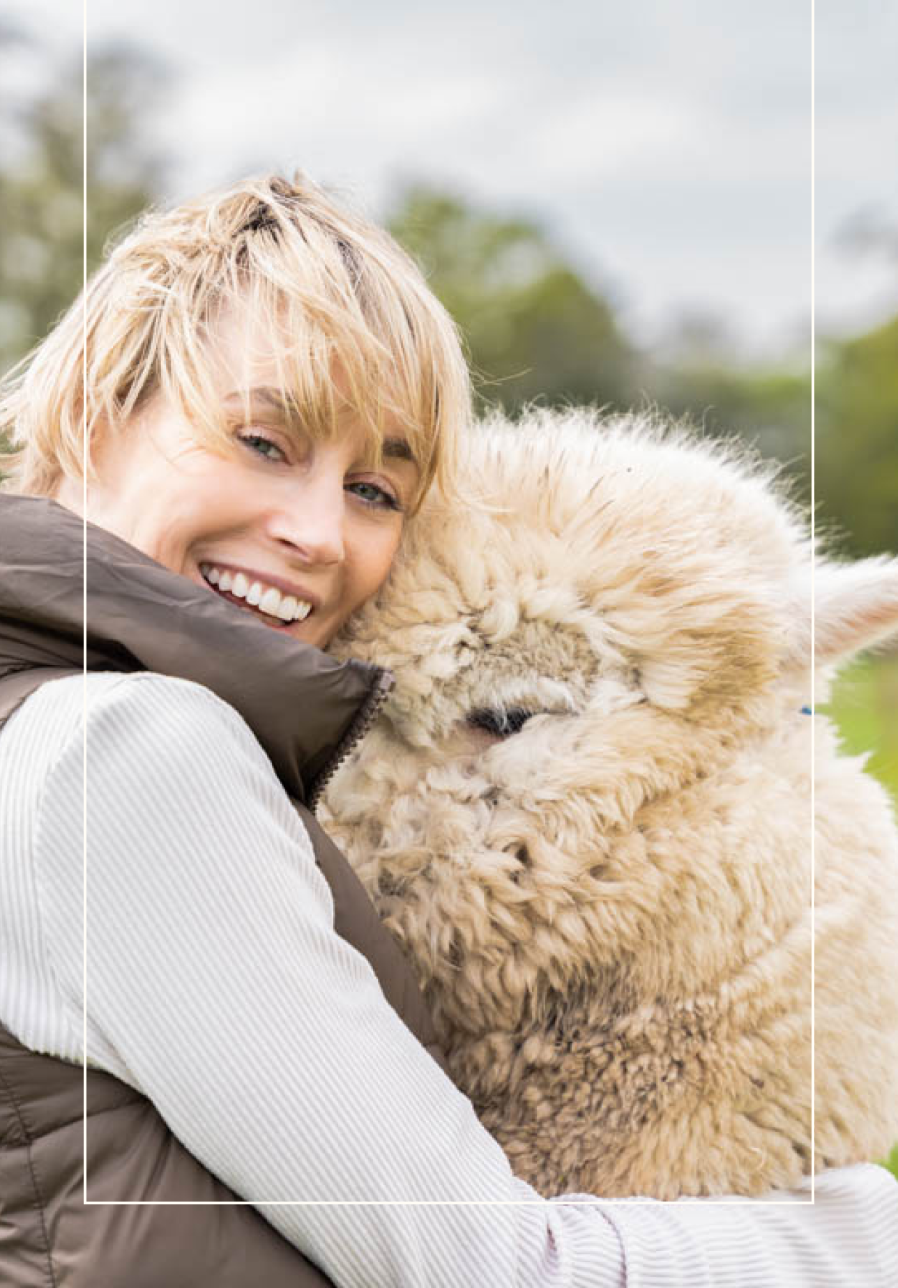 Picture of a lady hugging an alpaca